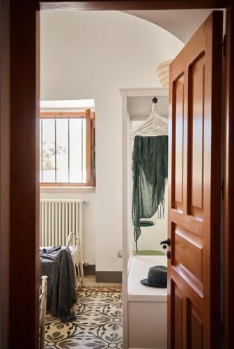 a hallway with a room with a bed and a window at Trullo Dei Fiori in Cisternino