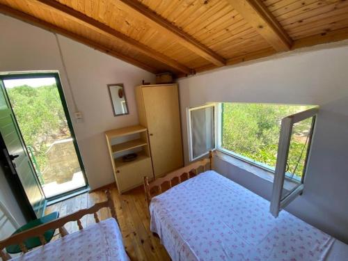 a small bedroom with a bed and two windows at House Kornati Robinzon in Sit