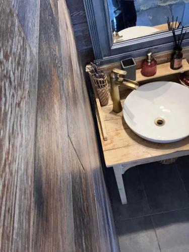 a bathroom with a white sink and a mirror at Csillagfény Házikó in Nagymaros