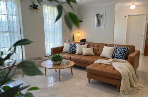 a living room with a brown couch and a table at Family Home Away From Home in Rockingham