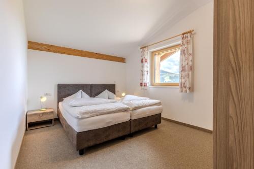 ein Schlafzimmer mit einem großen Bett und einem Fenster in der Unterkunft Zischgalm in Obereggen