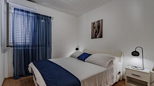 a white bedroom with a bed and a window at Villa Naty with Whirlpool by Villas Guide in Vela Luka