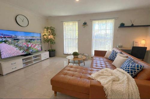 a living room with a couch and a large screen tv at Family Home Away From Home in Rockingham