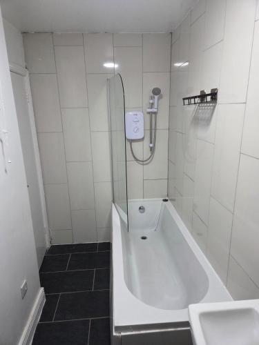 a bathroom with a shower and a tub and a sink at Modern 1-Bed in Wolverhampton City Centre in Wolverhampton