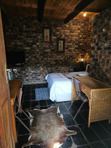 a bedroom with a bed in a brick wall at Die Kliphuisie Gastehuis in Vryburg