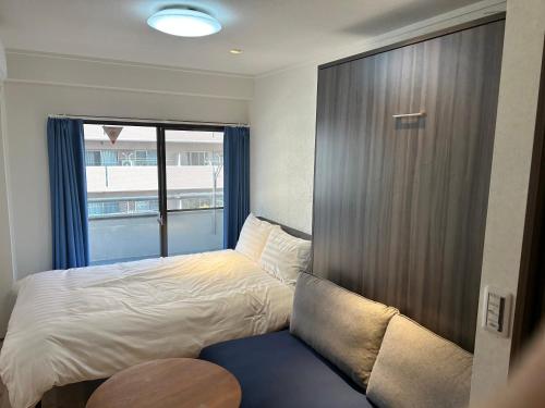 a small bedroom with a bed and a window at Eko House in 横浜石川町駅 601室 in Yokohama