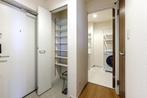 a closet with a door open to a laundry room at The Top名駅 in Nagoya