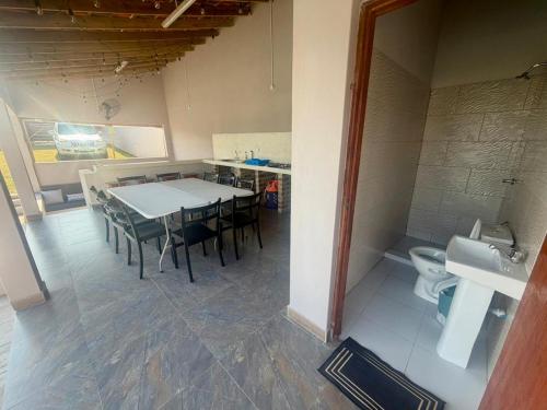 a dining room with a table and a toilet at Ponta Rest House in Lopes