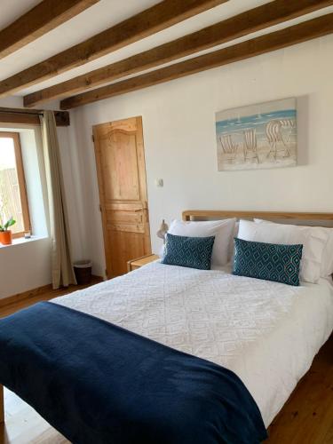 a bedroom with a large bed with blue pillows at La Grange bnb in Yviers