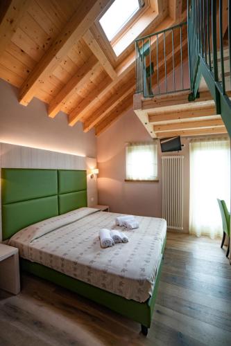 a bedroom with a large bed with a green headboard at Malga Zebari in Velo Veronese