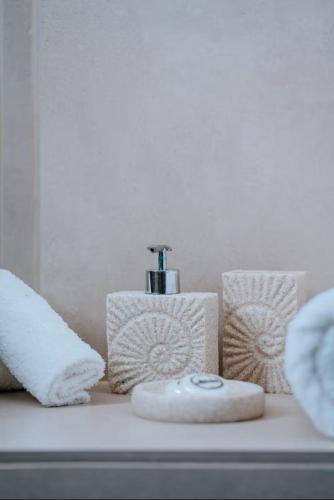 a bathroom counter with a soap dispenser and towels at Casa View in Akrotiri