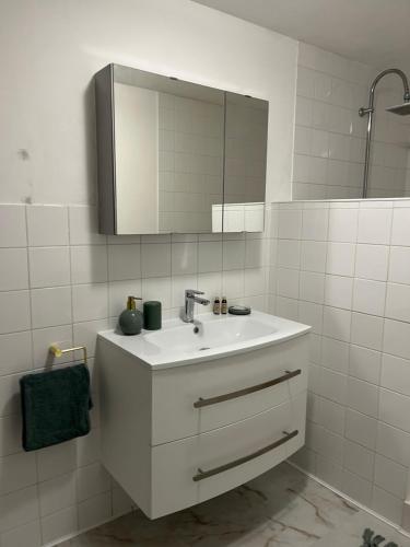 a white bathroom with a sink and a mirror at La Grange bnb in Yviers