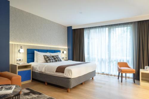 a bedroom with a king sized bed and a chair at Avissa Suites in Jakarta