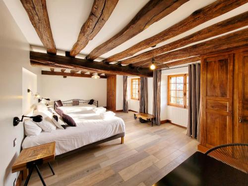 a bedroom with a large bed and wooden ceilings at Jardin des Sens, la Rente d'Eguilly in Éguilly