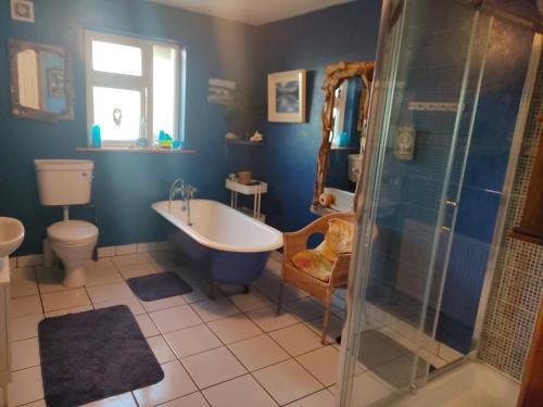 a bathroom with a tub and a toilet and a sink at Hidden Hearts Haven Spa in Lelagh