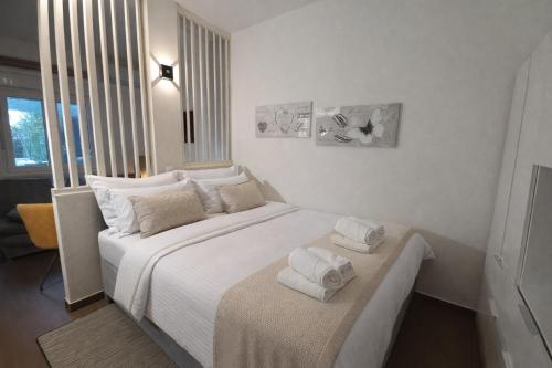 a bedroom with a large white bed with towels on it at Studio apartment with pool in Pula