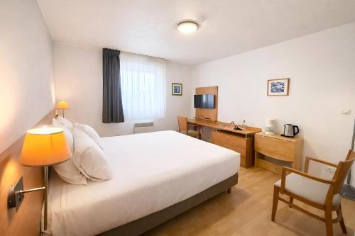 a bedroom with a bed and a desk and a chair at Séjours & Affaires Bordeaux de L'Yser in Bordeaux