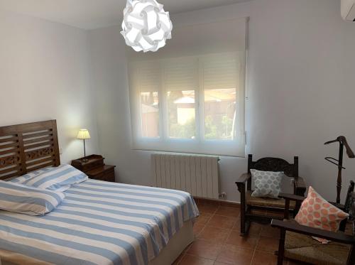 a bedroom with a bed and a chandelier at Enjoy Toledo, junto a Puy du Fou in Argés