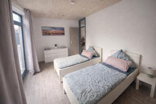 a small bedroom with two beds and a window at Charmante FeWo in Dorflage in Ebersdorf