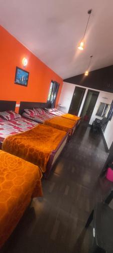 a row of beds in a room with orange walls at AFIYA HOME STAy in Kodaikānāl