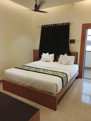 a bedroom with a large bed with a black curtain at Hotel Gurudev Inn in Junnar