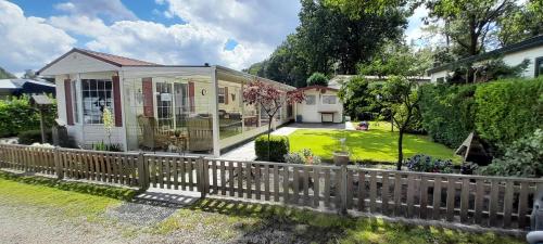 a small house with a fence in the yard at Vakantiepark Klein Vink - 25 in Arcen