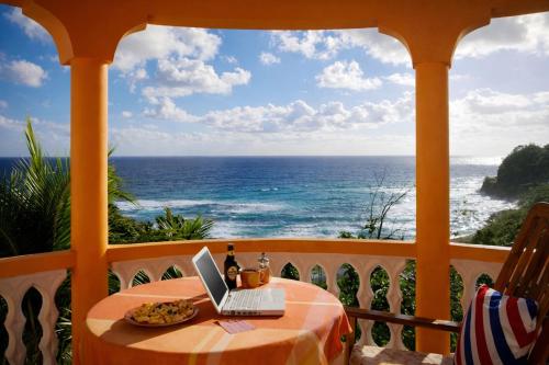 a balcony with a table with a laptop on it at I VIEW - in Long Bay in Long Bay Village