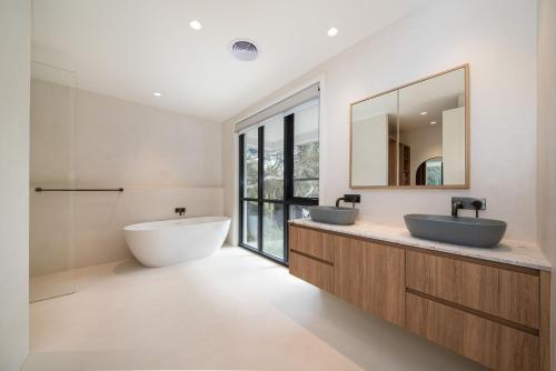 a bathroom with two sinks and a tub and a mirror at The Hudson with Heated Pool in Rye