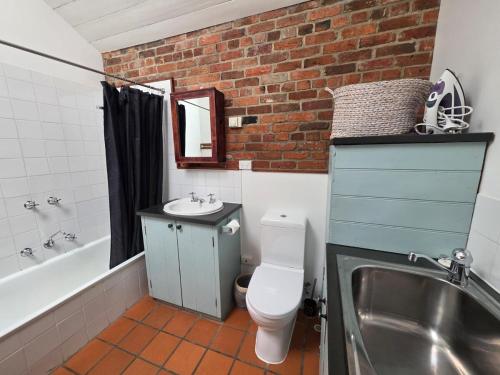 a bathroom with a sink and a toilet and a bath tub at Cascade Cottage Circa 1840 in West Hobart
