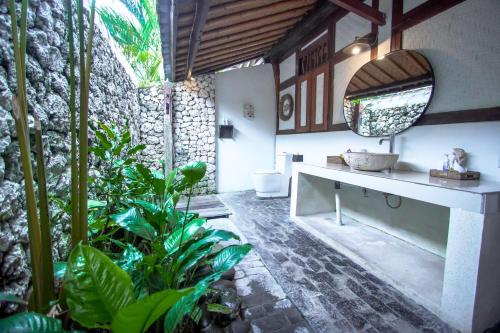 a bathroom with a sink and some plants at The Calmtree Bungalows in Canggu