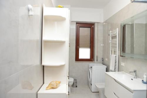 a white bathroom with a sink and a toilet at VicoStay di Casa Stella in Vico Equense