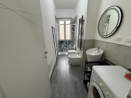 a white bathroom with a sink and a toilet at Arcobaleno in Turin