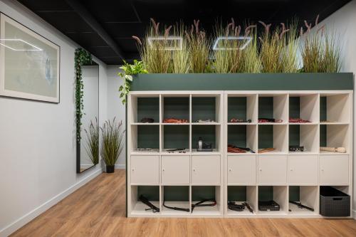 a white cabinet with glass doors with plants at BDSM Play Apartments in Vilnius