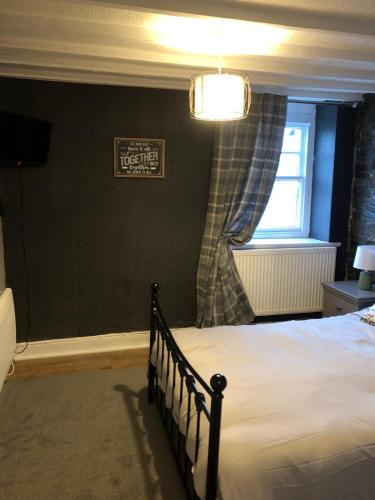 a bedroom with a bed and a window at Cosy Pubs Bed & Breakfast in Rhayader