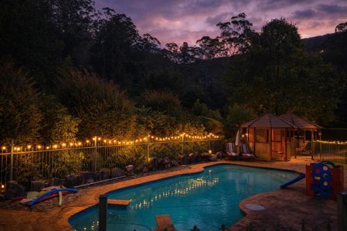 a swimming pool with lights on a fence at Oasis of Hope - Wellness Retreat Guest Wing in Upper Orara