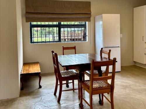a kitchen with a table and chairs and a refrigerator at Shiloh Lodges Tweefontein in Mooiriver
