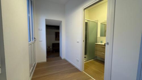 an empty hallway with a mirror and a bathroom at Glicine in Stresa