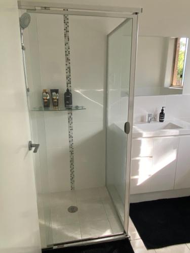 a shower with a glass door next to a sink at Luxurious 3 Bedroom Executive Home-Private Retreat in Higgins
