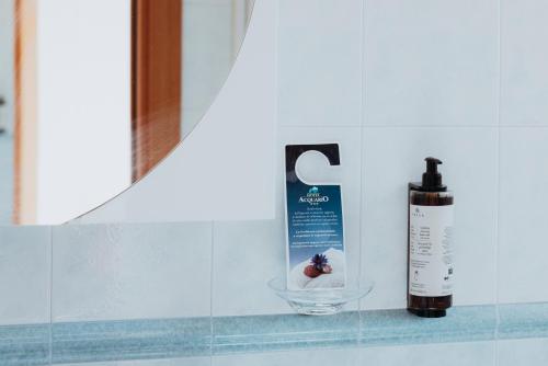 a bottle of mouthwash sitting next to a bathroom mirror at Hotel Acquario in Vasto