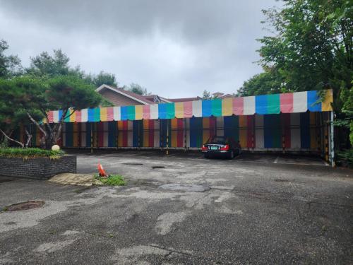 a building with a colorful banner in a parking lot at 레미니스호텔 in Dongtan