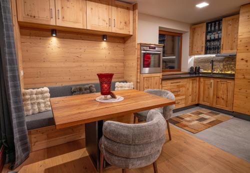 a kitchen with a wooden table and chairs at Apart Alpin in Heiligenblut