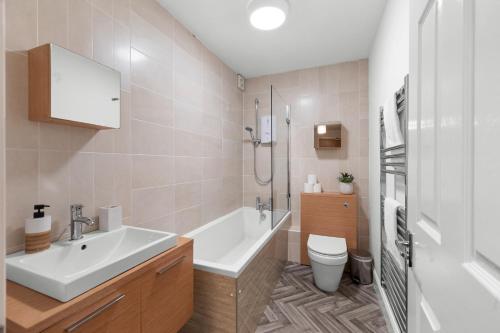 a bathroom with a sink and a tub and a toilet at Commercial Street Residence in Dundee