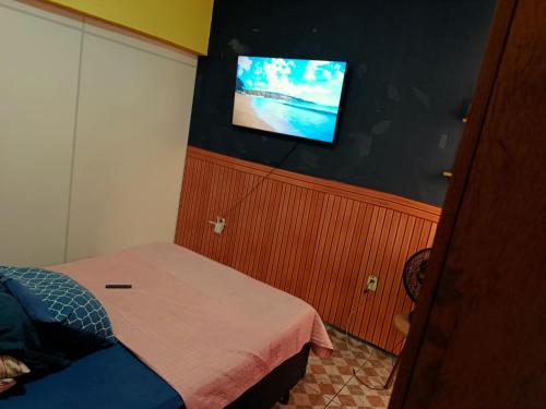 a bedroom with a bed and a tv on the wall at Hospedaria e alojamento da Taty in Tatuí