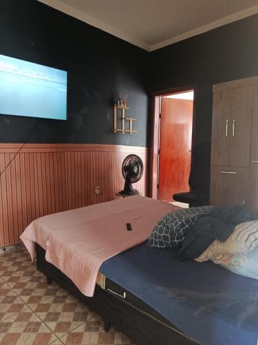 a bedroom with a large bed with a flat screen tv at Hospedaria e alojamento da Taty in Tatuí