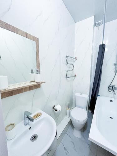 a white bathroom with a sink and a toilet at Bekarys Twins in Astana