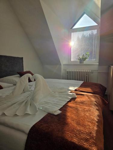 a bedroom with a white bed with a window at Hotel Skicentrum in Harrachov