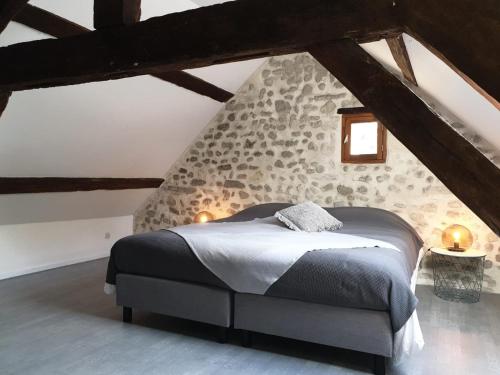 a bedroom with a large bed in a attic at Le Moulin en Route in Blèves