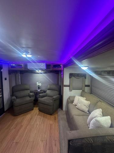 a room with a couch and two chairs and purple lights at Alojamiento in Tampa