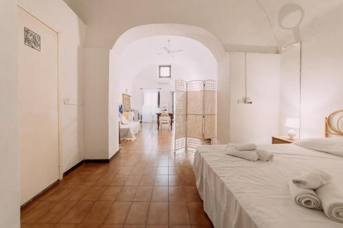 a white room with a bed and a hallway at Domus Gallipoli by Casa di Marco in Gallipoli