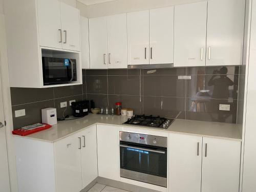 a kitchen with white cabinets and a stove top oven at Luxurious 3 Bedroom Executive Home-Private Retreat in Higgins